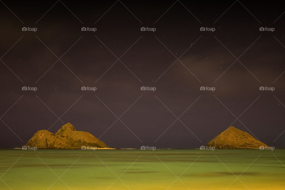 View of idyllic sea and rock at night