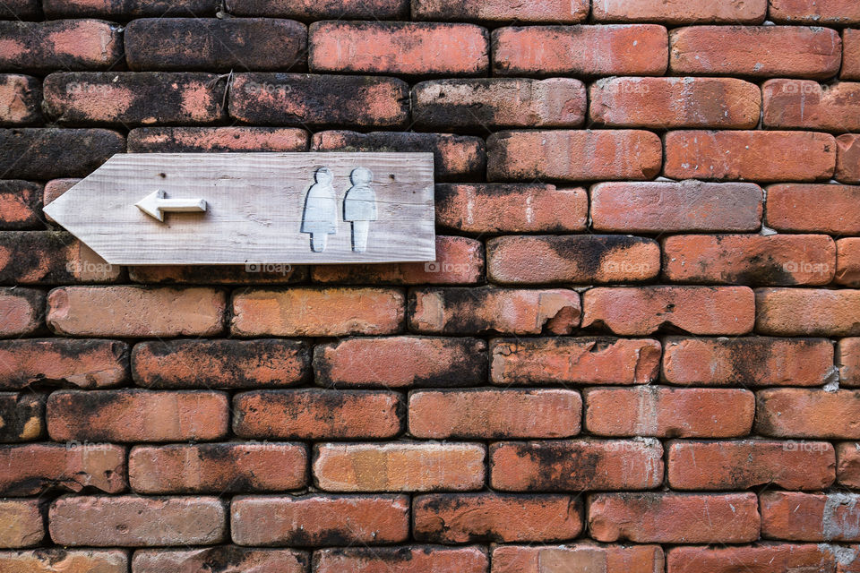 Restroom sign on the red brick wall