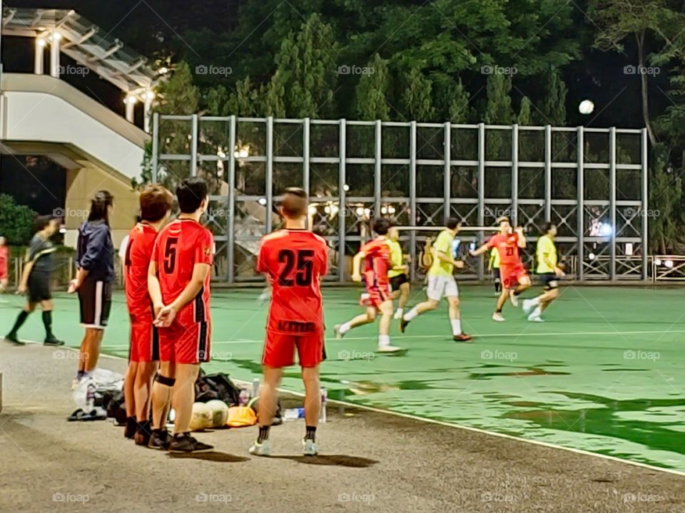 Men playing soccer after the rain at Hong Kong Victoria Park