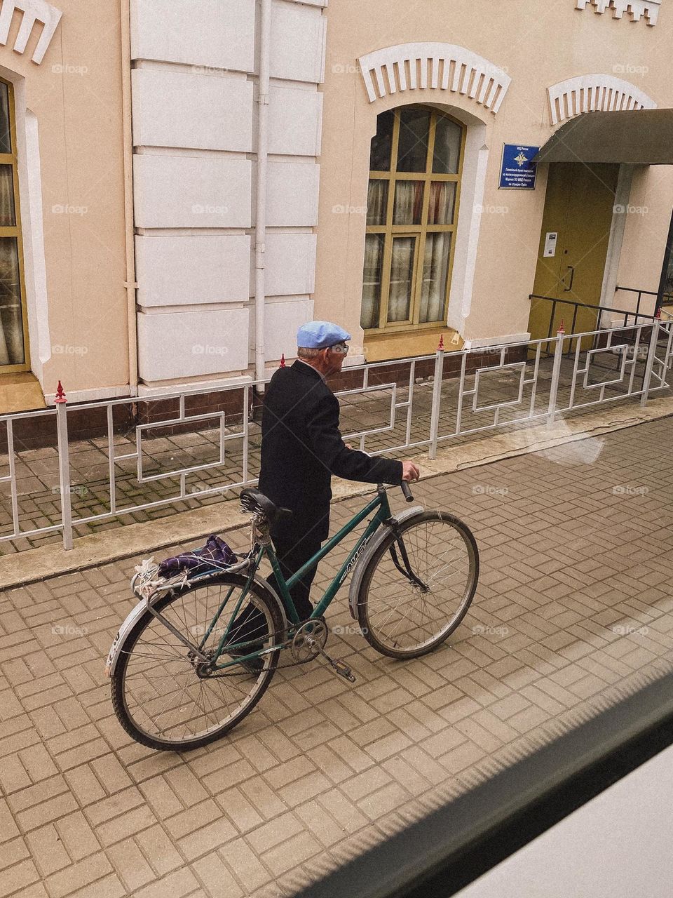 grandfather with bicycle on the railway station
