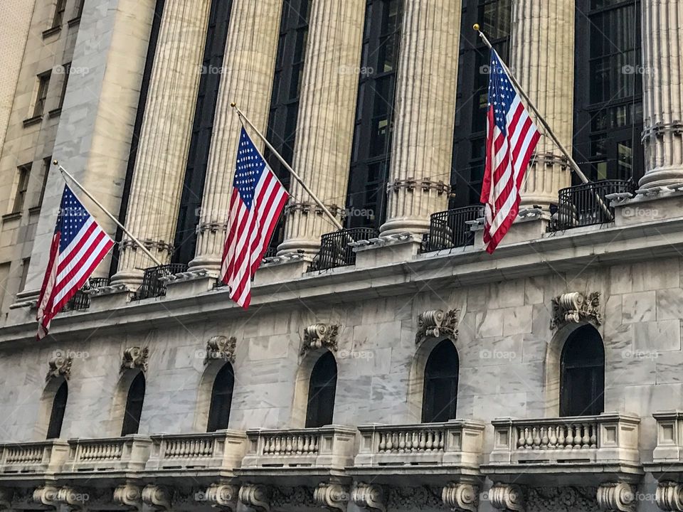 American flags hanging on the Wall Street building