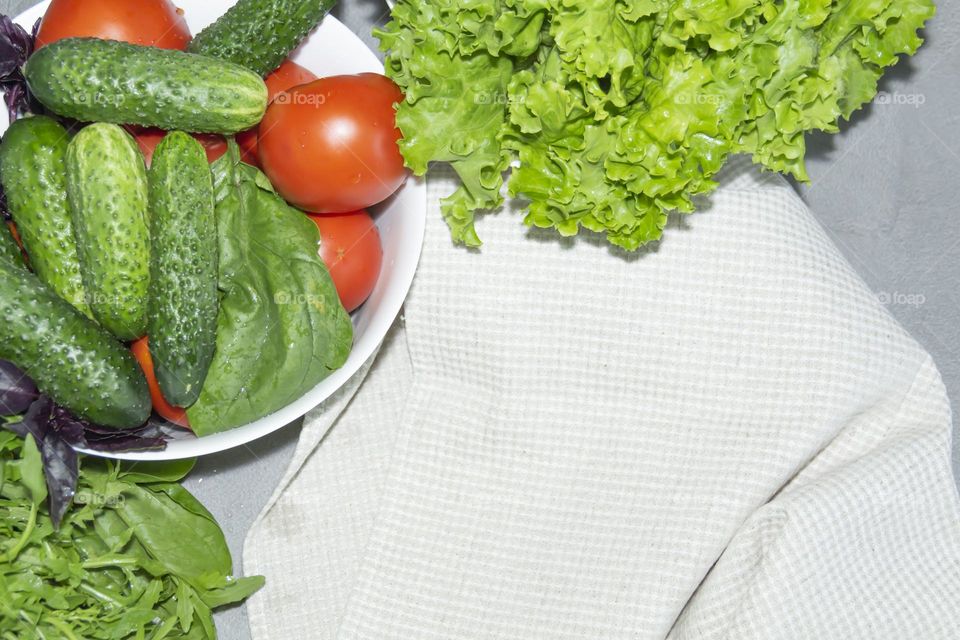 Vegetables and greens on a table with a linen towel.