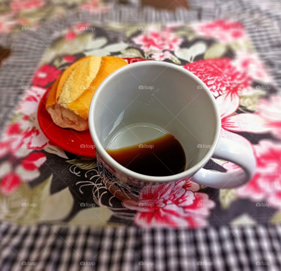 Black coffee at the bottom of the mug with bread