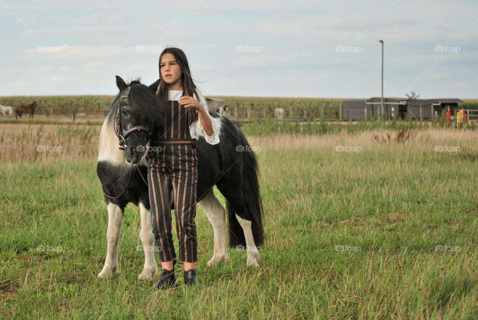 Teenage girl riding her horse in nature in the countryside