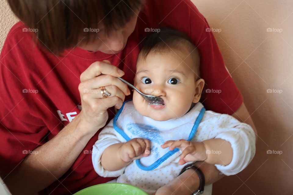 Young mom is feeding her baby