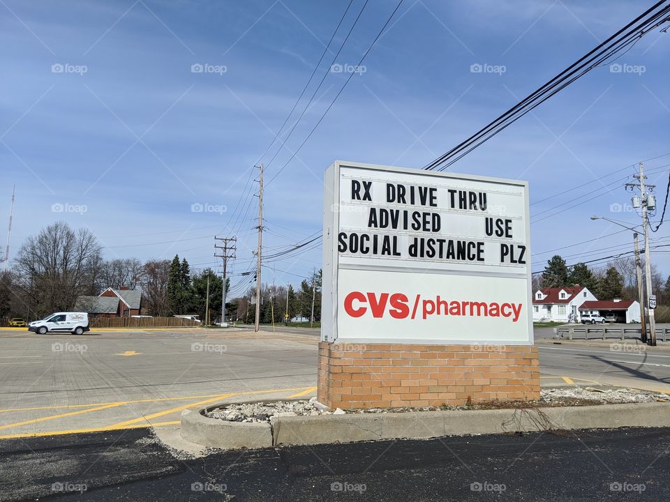 sign at a CVS in Parma, Ohio asking people to social distance and use the drive through