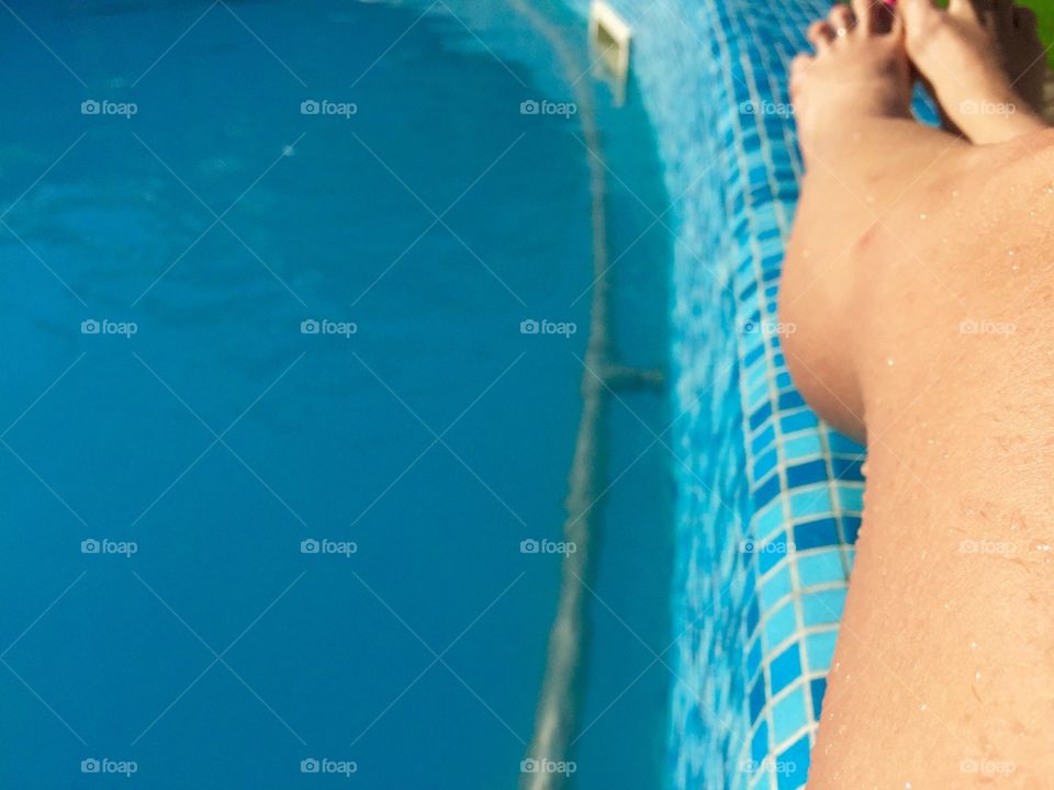 Woman's wet legs near the pool
