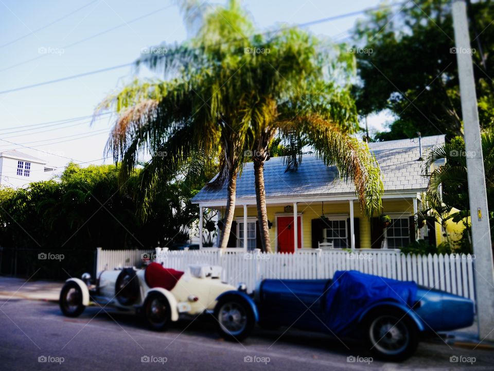 Old cars in front of a house 