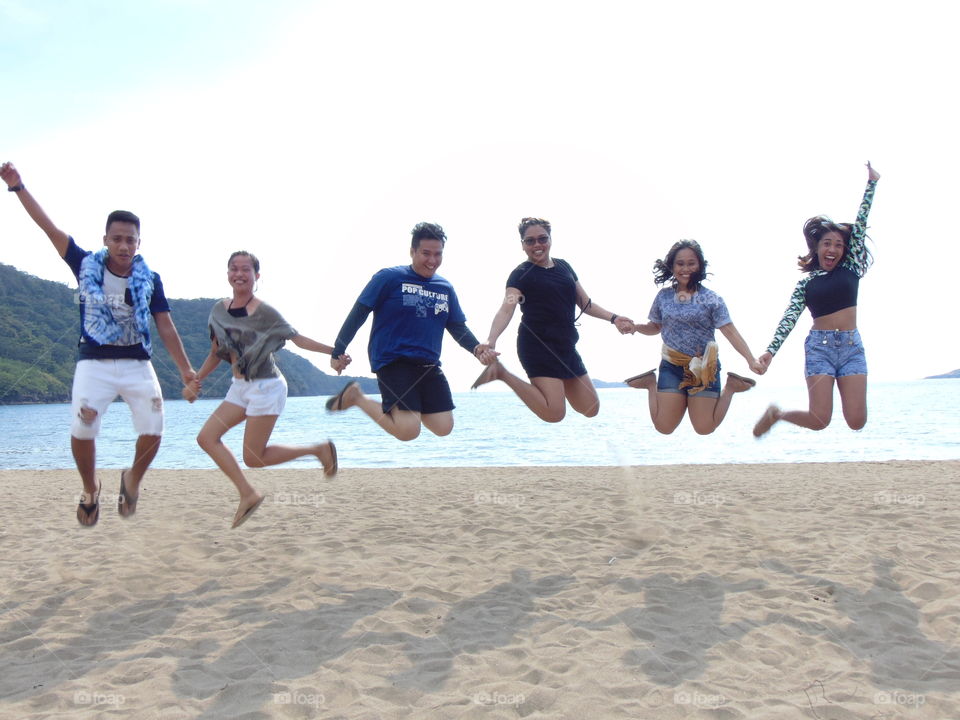 a jumpshot with a geoup of friends by the beach