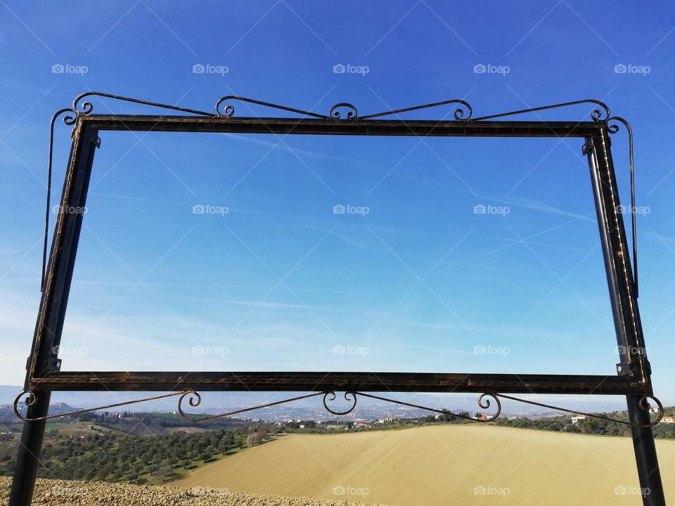 Country landscape framed by a wrought iron structure