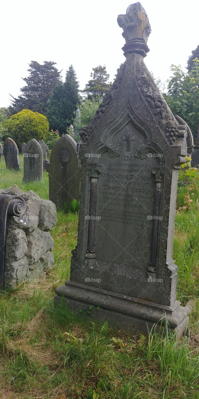 row of old stone gravestones tombstones in cemetery