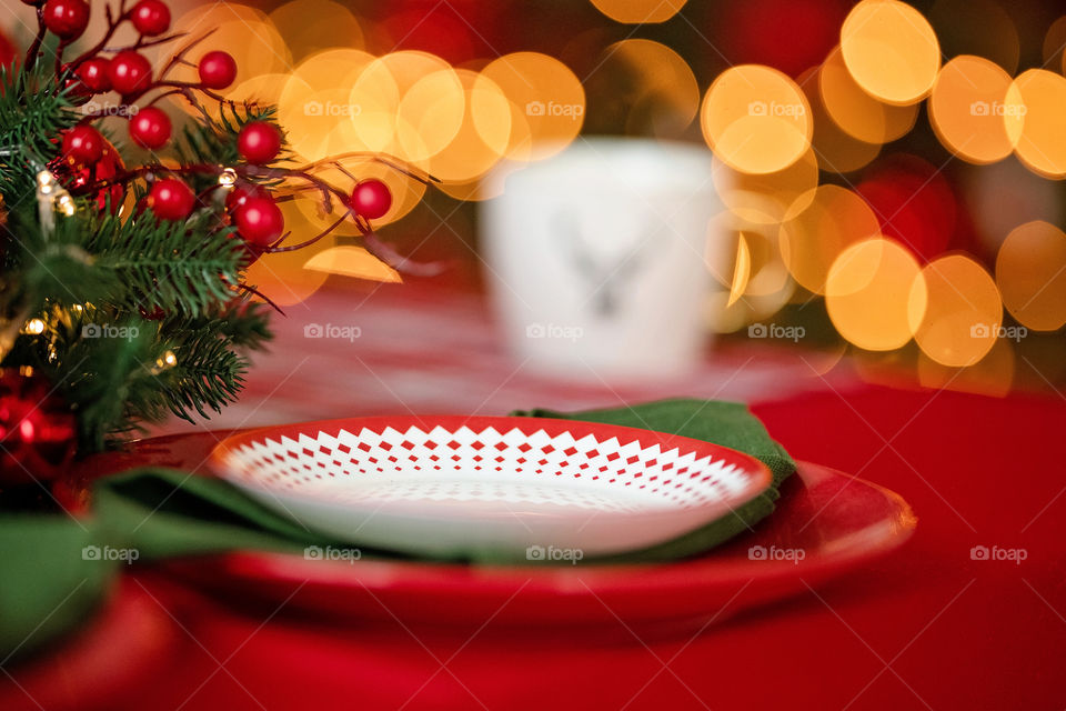 Festive winter cozy kitchen interior with garlands, decorations and gifts.  Christmas dinner at the decorated table.