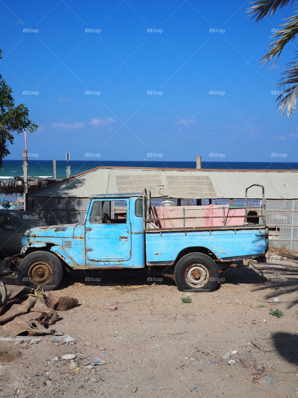 Blue abandoned vehicle on the beach