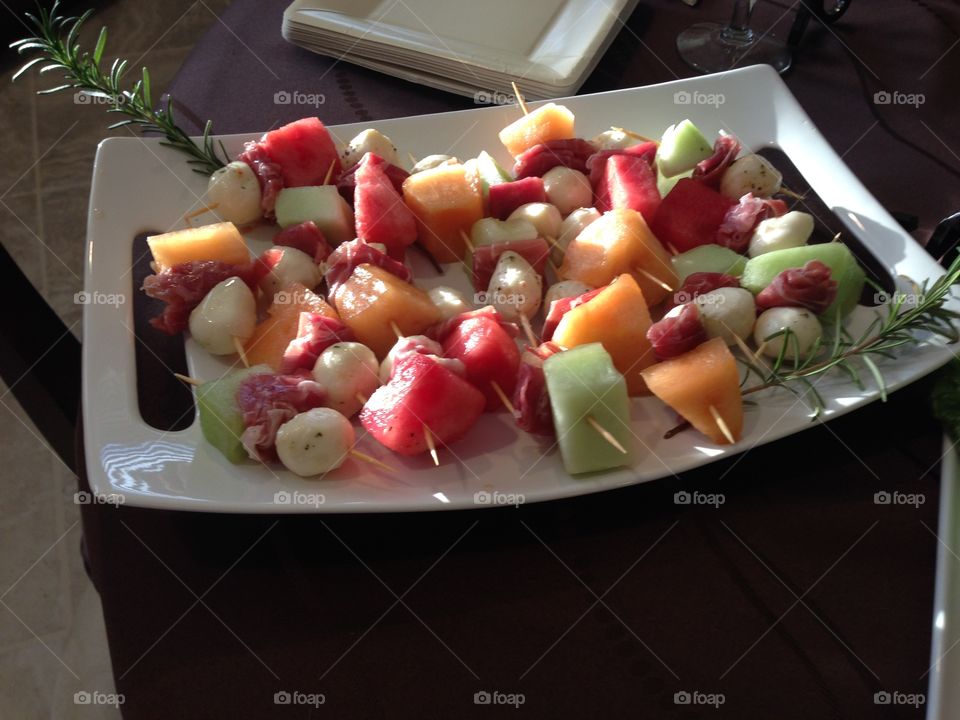 Fruit skewers ready to be eaten.  A fresh and colorful display of fruit.