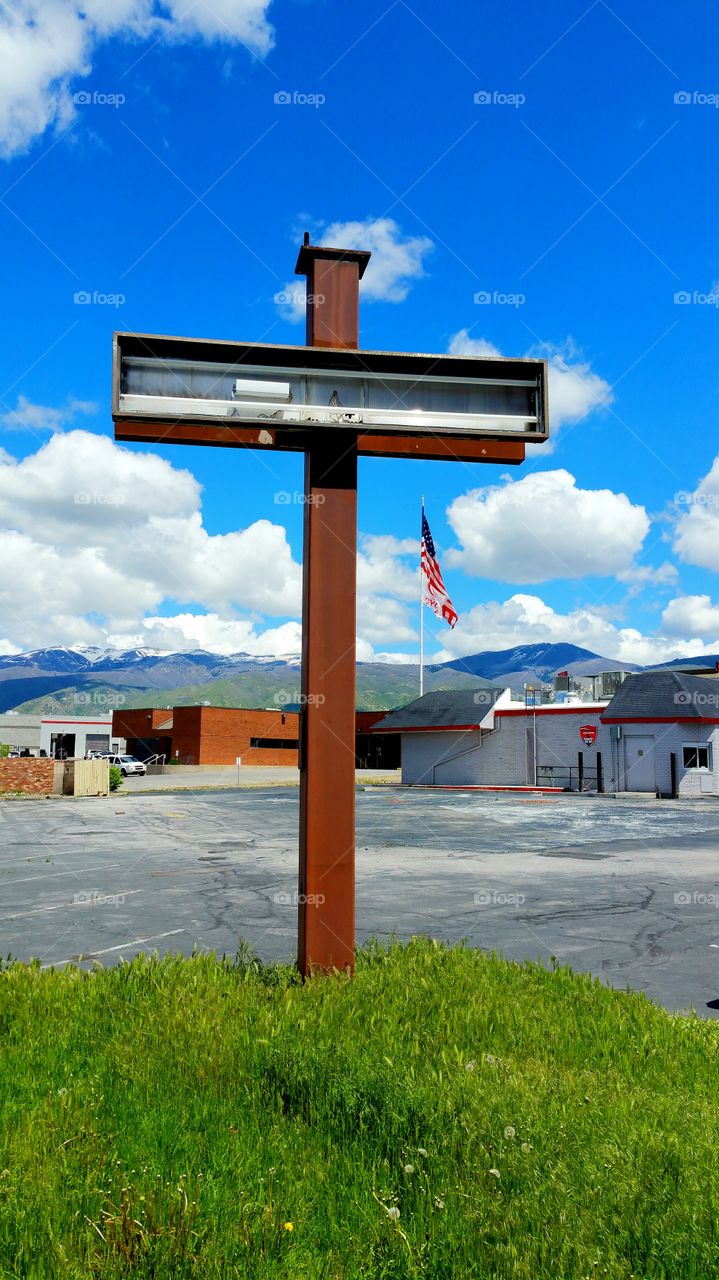 cross shaped beam with flag in background