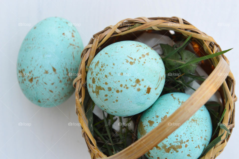 Top view of a small basket with painted Easter eggs