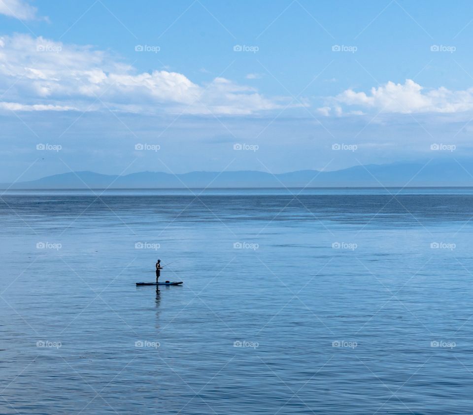 Fishing on a paddle board in the middle of Pacific Ocean