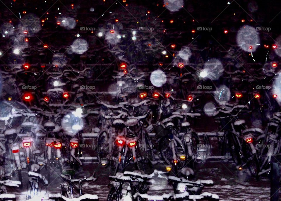 bicycles parked at a train station on a winter night