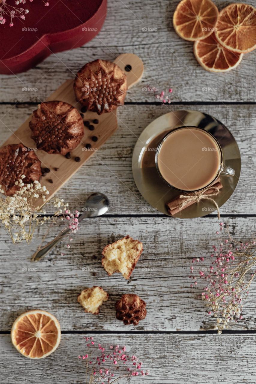 Flat lay coffee latte and homemade muffins on wooden background