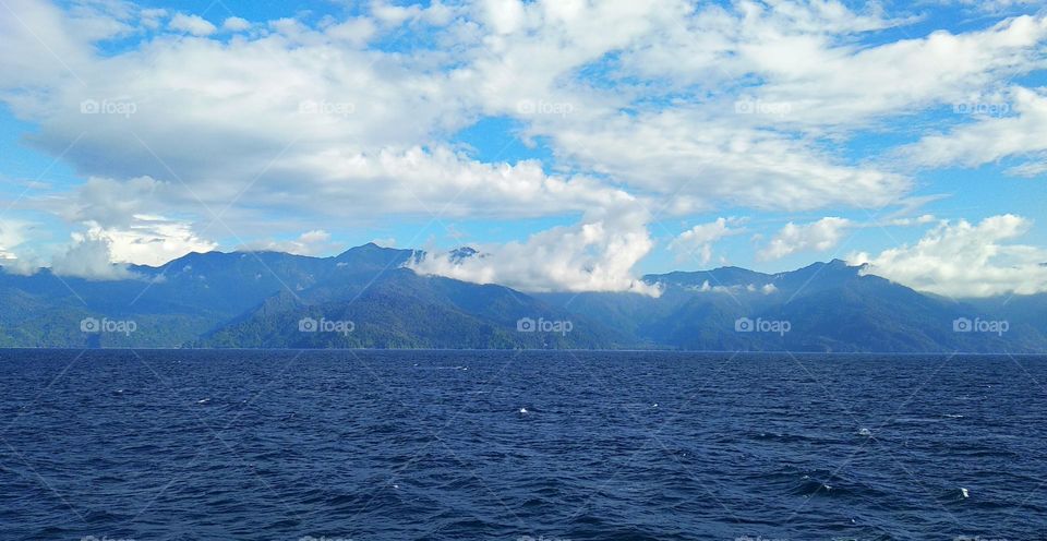 The beauty of nature, view of the clouds over the mountains and the blue sea.