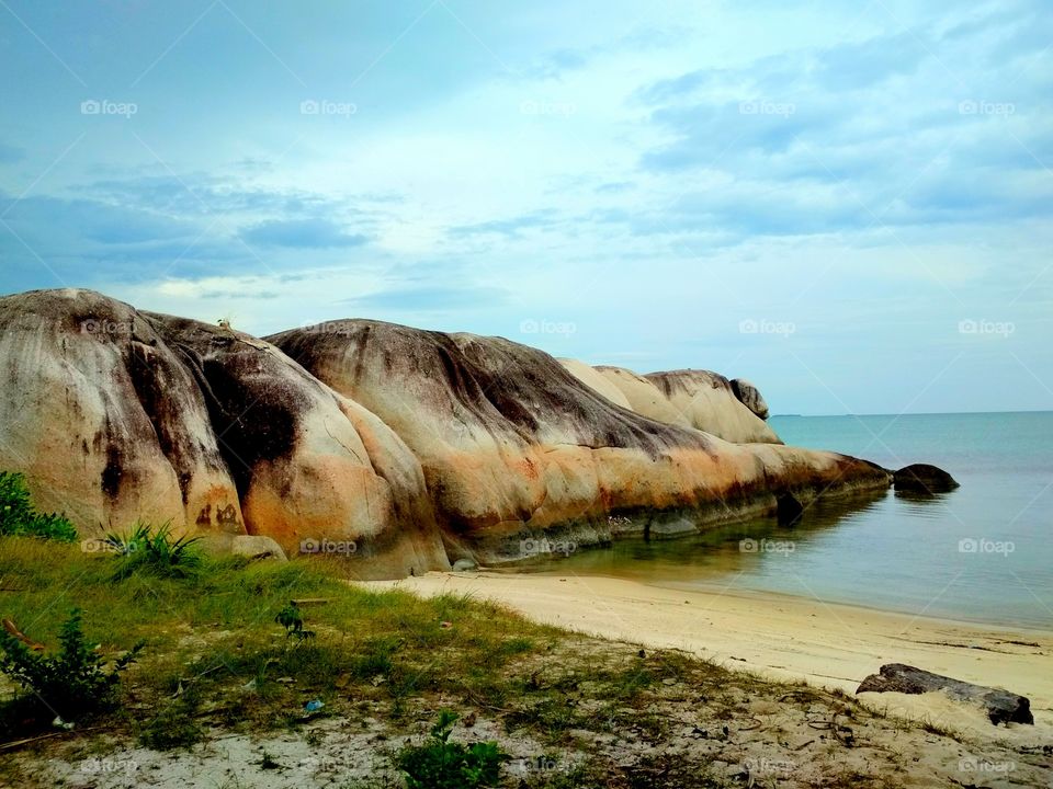 Big granite rock into the sea