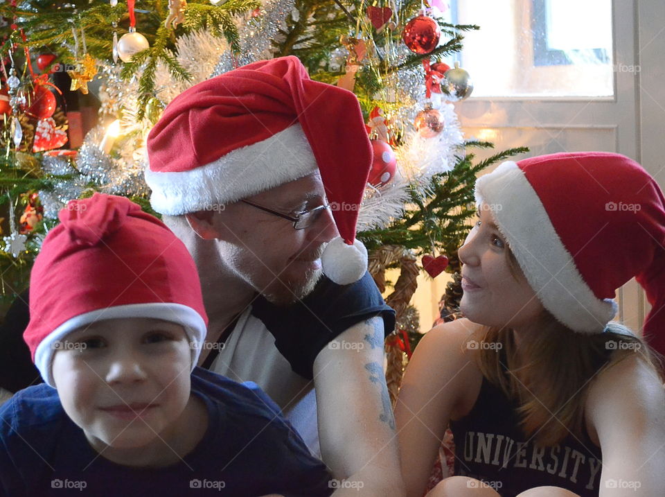 Father with his children in front of a christmas tree