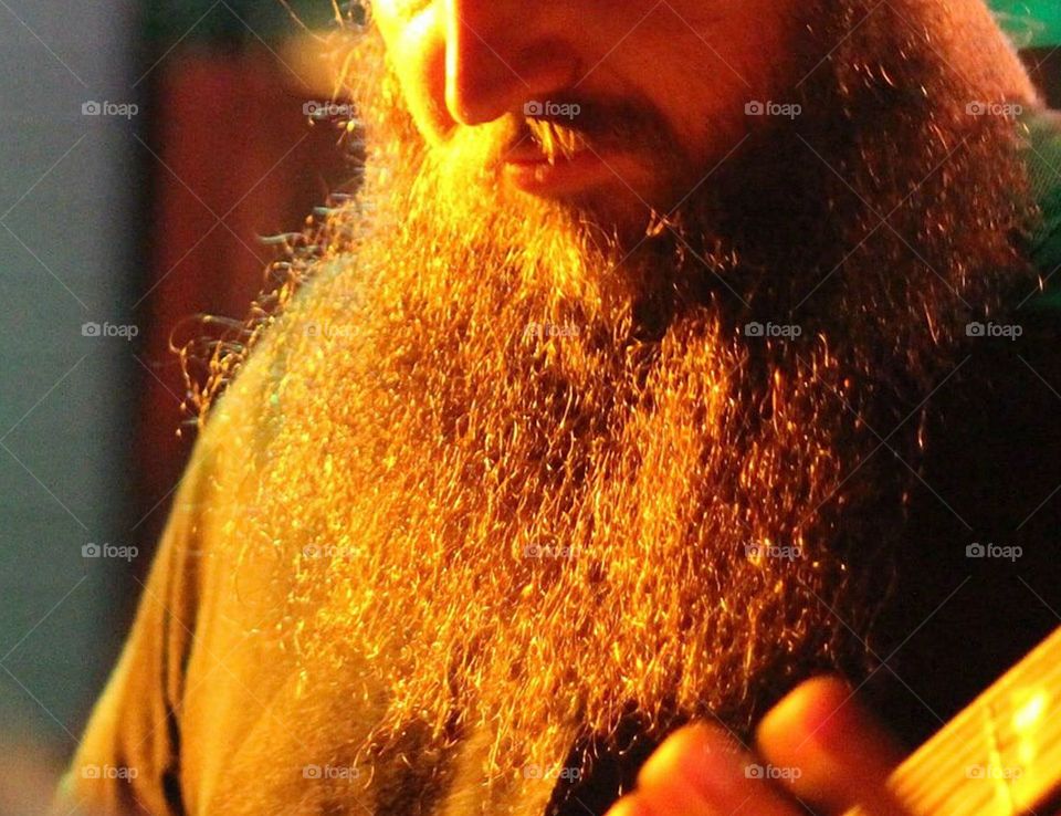 Bass players beard is glowing as he jams 