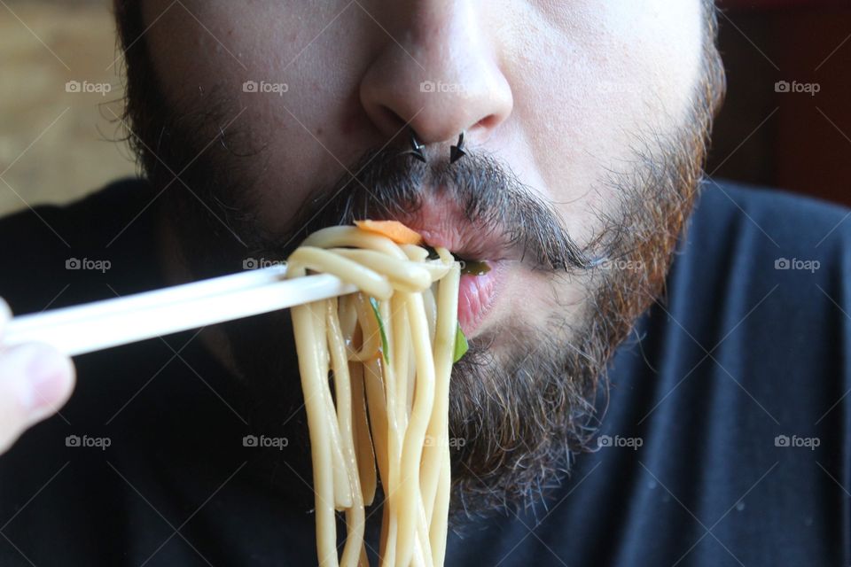 Beard man eating noodles 
