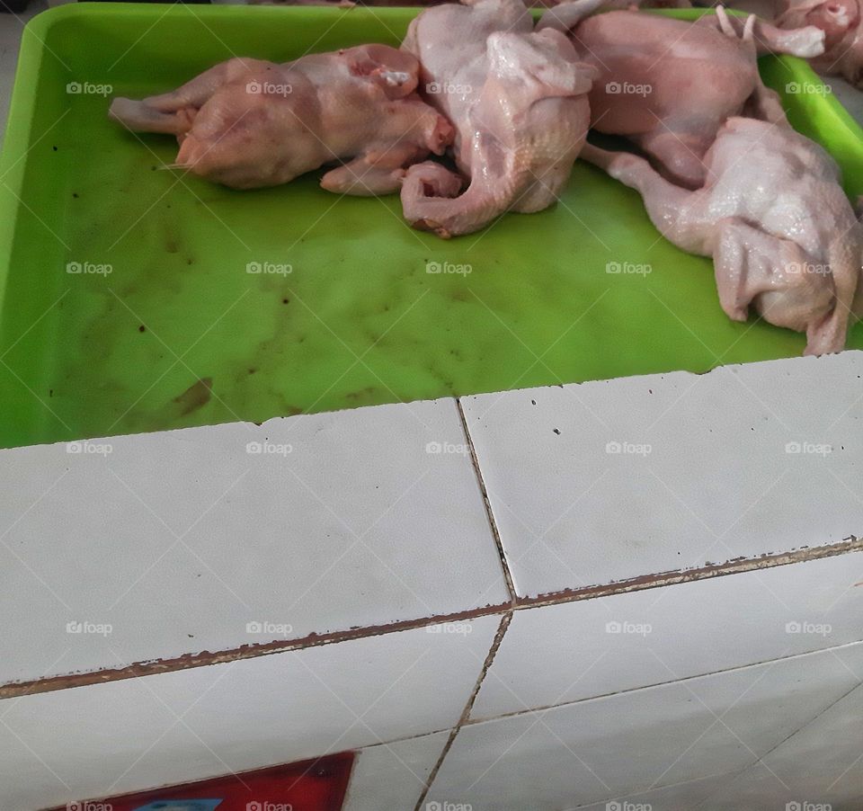 Much chicken meat placed on the green board and sold in the traditional market in Sanur - Bali