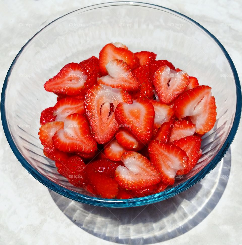 sliced strawberries. sliced strawberries in glass bowl