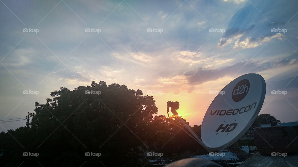 Radiant Evening Sunset, shinning / flamming behind the satellite - dish, a warm and cloudy sky / Random click