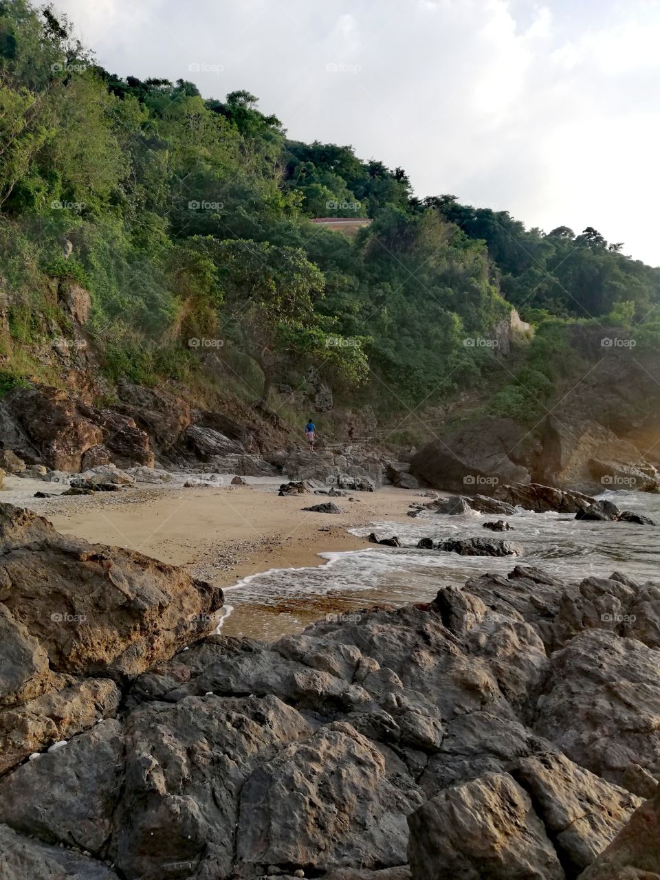 Dreamy beach scenery, sandy rocky beach surrounded by tropical rainforest hills and tropical Chinese Sea