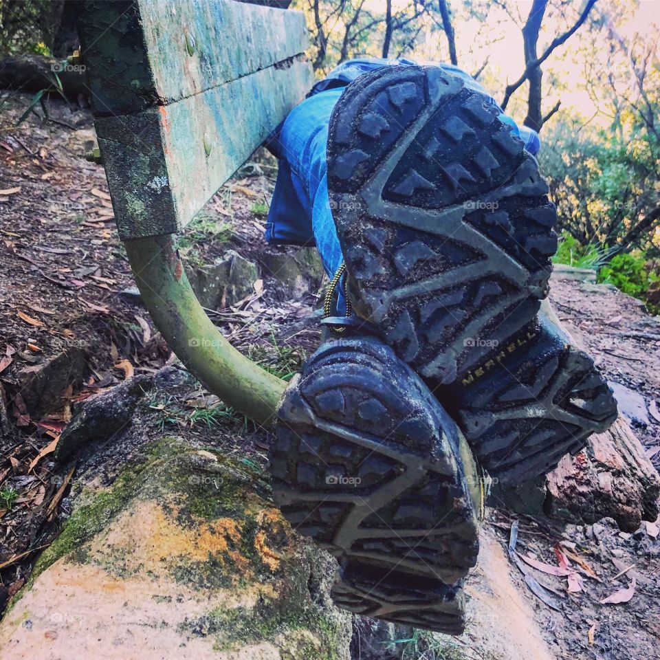 Merrell hiking boots underneath- lying on a bench