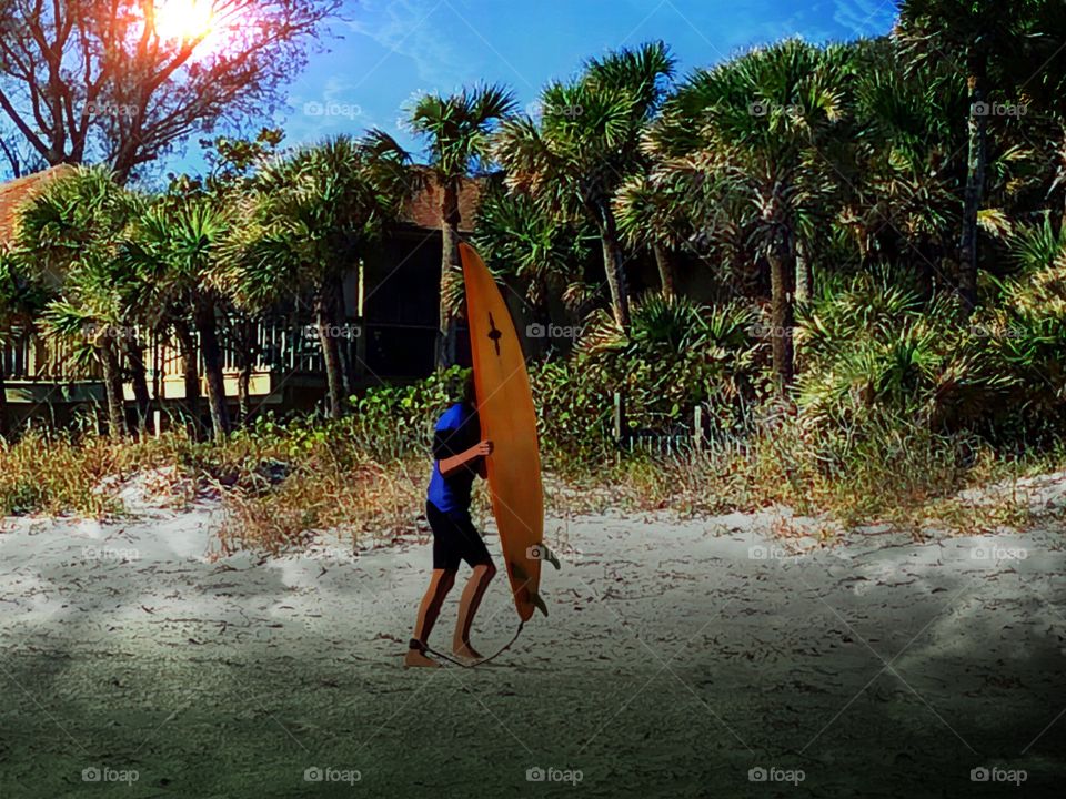 Surfer on the beach getting ready to launch his surfboard.