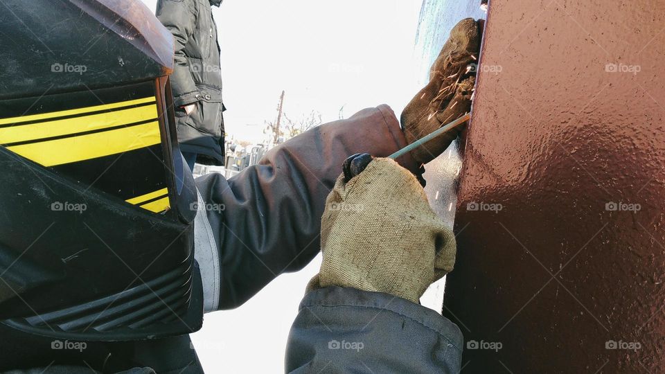 Welder work with metal construction overalls