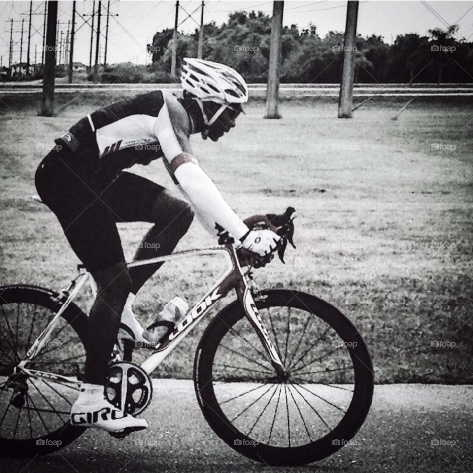 Riding time . Cyclist riding a bike in black and white 