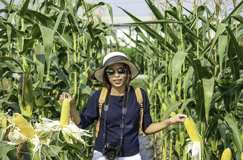 A woman holding the corn at the show in the farm.