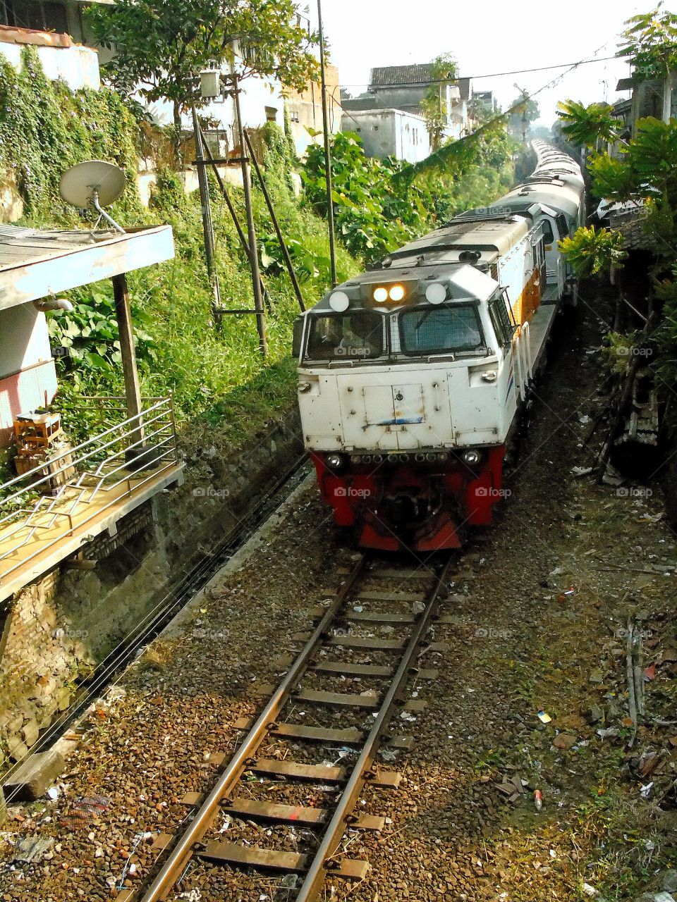 Bima Train, which has a route from Gambir Railway Station in Jakarta to Malang Railway Station, prepares to entering Malang Railway Station passes a curve with GE CM20EMP (CC 206).