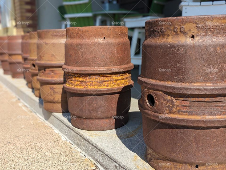 rusty kegs lined up outside brewery, old beer memorabilia, rust beer kegs, brewery kegs