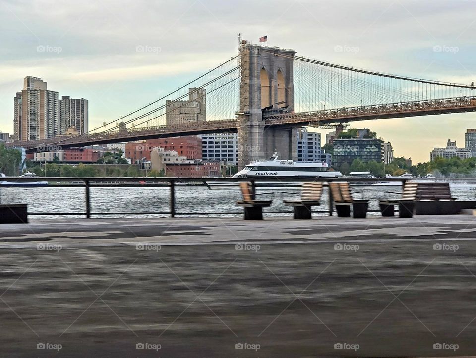 The Brooklyn Bridge as a ferry passes below it