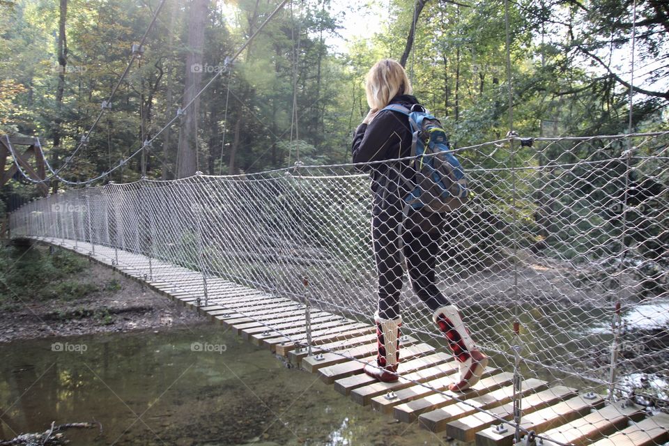 Woman hiking across bridge in Ohio, USA