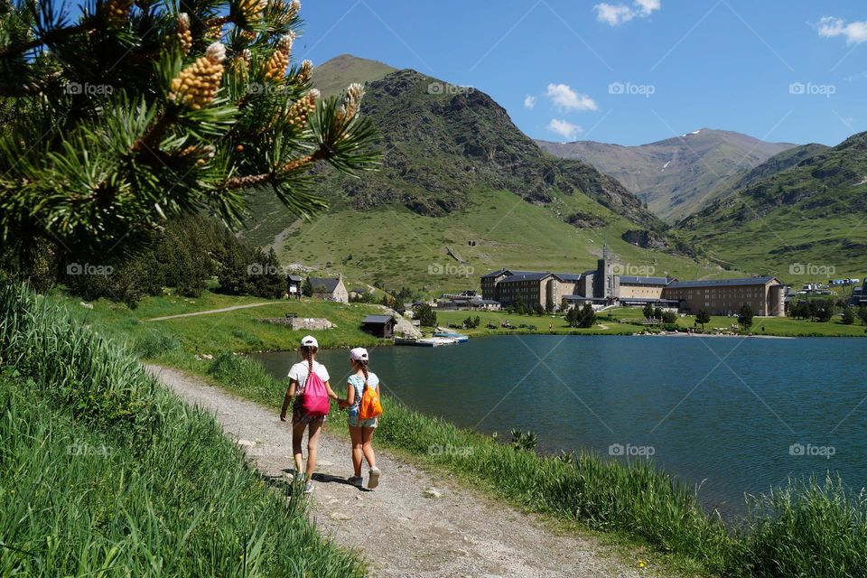 Children walk along the road along the lake