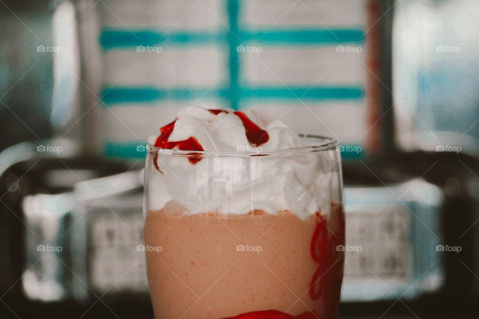 close up delectable strawberry milkshake with whipped cream and strawberry sauce 
