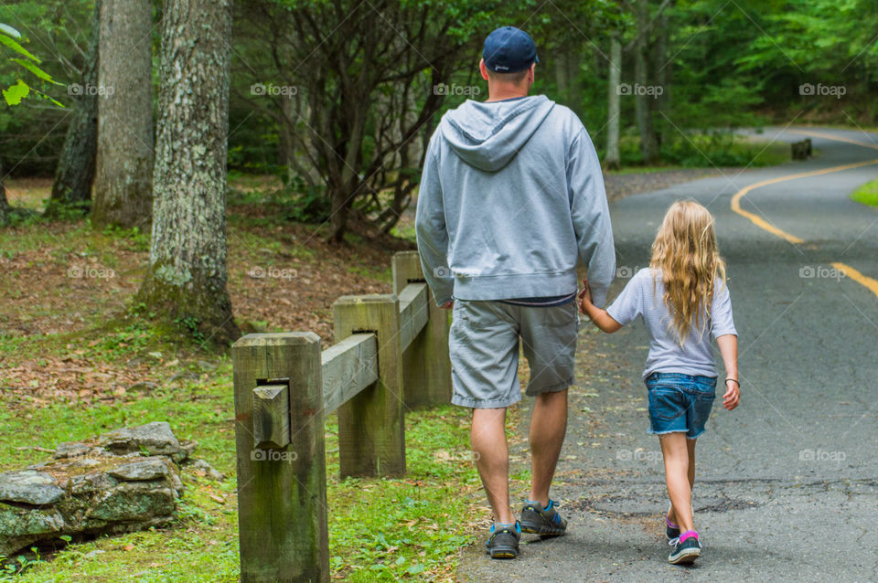 Rear view of people walking on road
