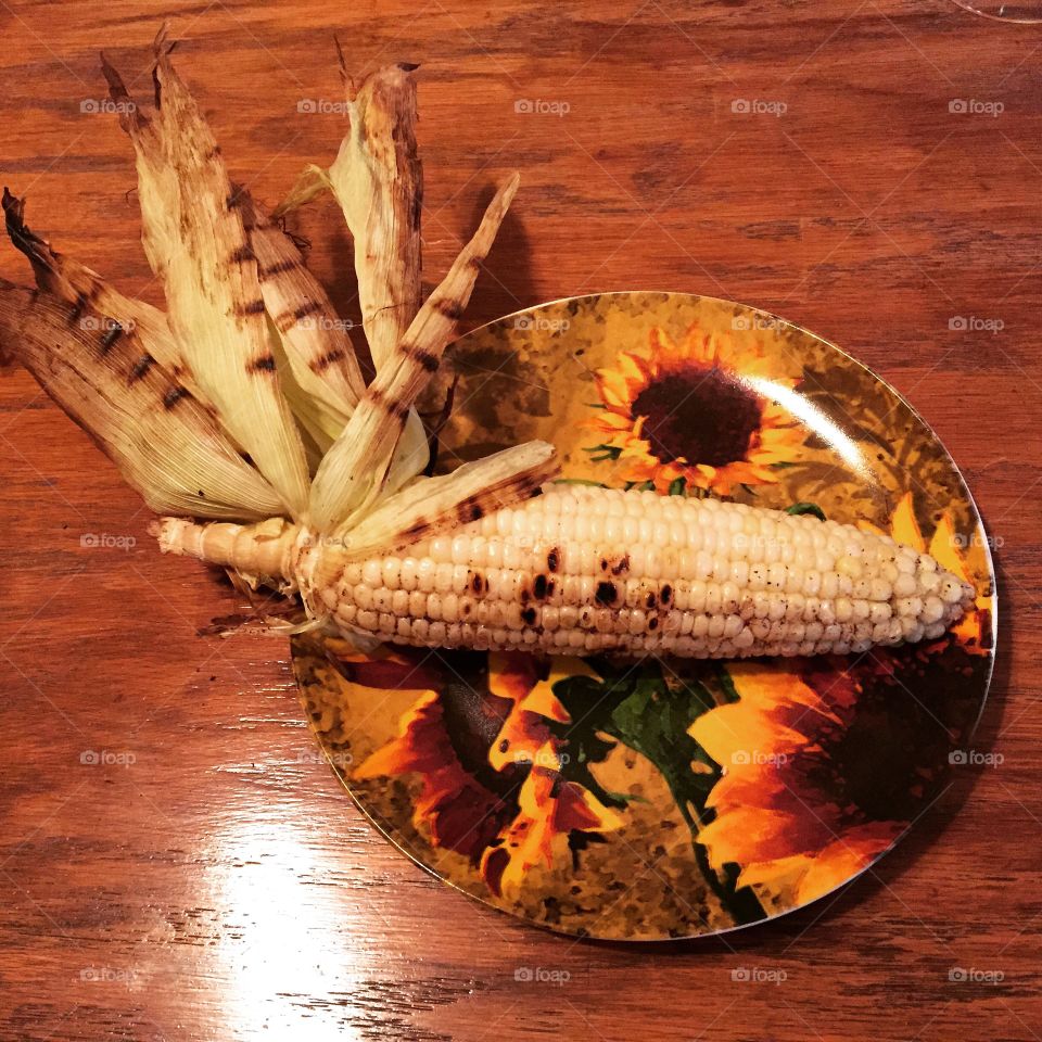 Grilled corn on sunflower plate
