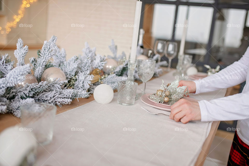 man sets a beautiful decorated winter table for a festive dinner.  Merry Christmas and Happy New Year.