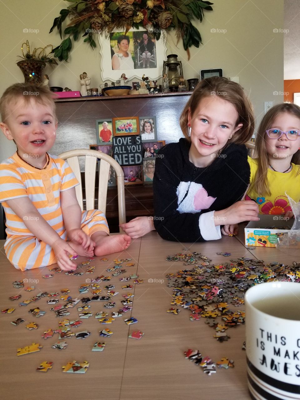 Beautiful Sunday morning family time with the kids doing a puzzle. Everyone is enjoying themselves in their pjs.