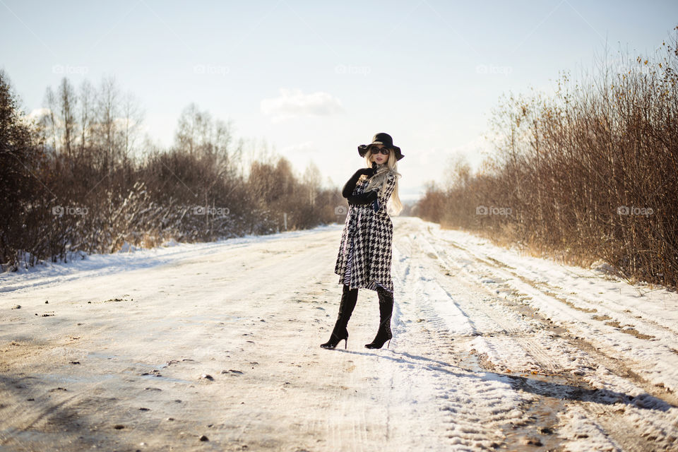 girl in a coat and hat on the road