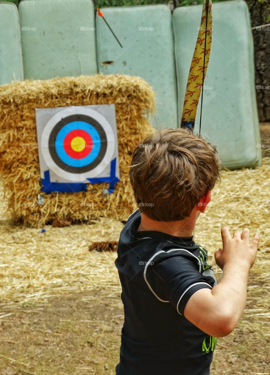 Shooting Arrows. Boy With Bow And Arrows At An Archery Range
