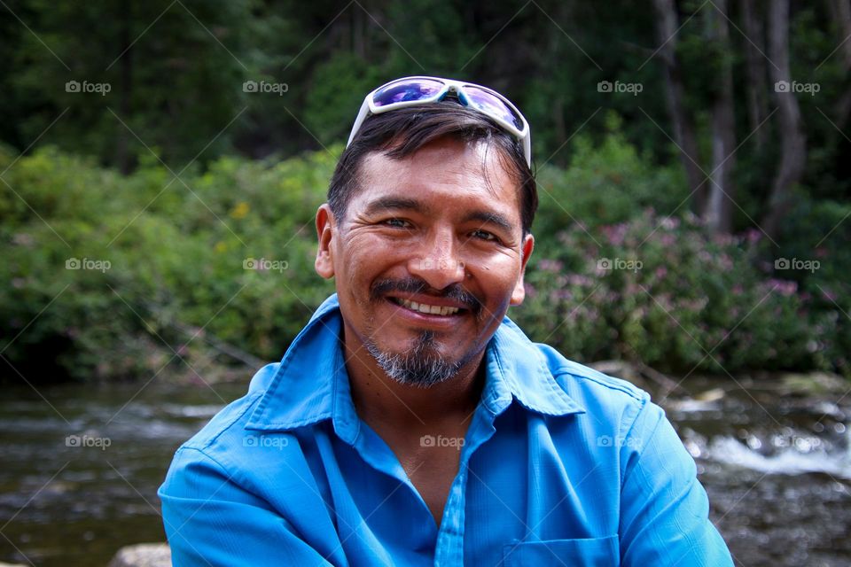 Man with beard is smiling sitting outdoors